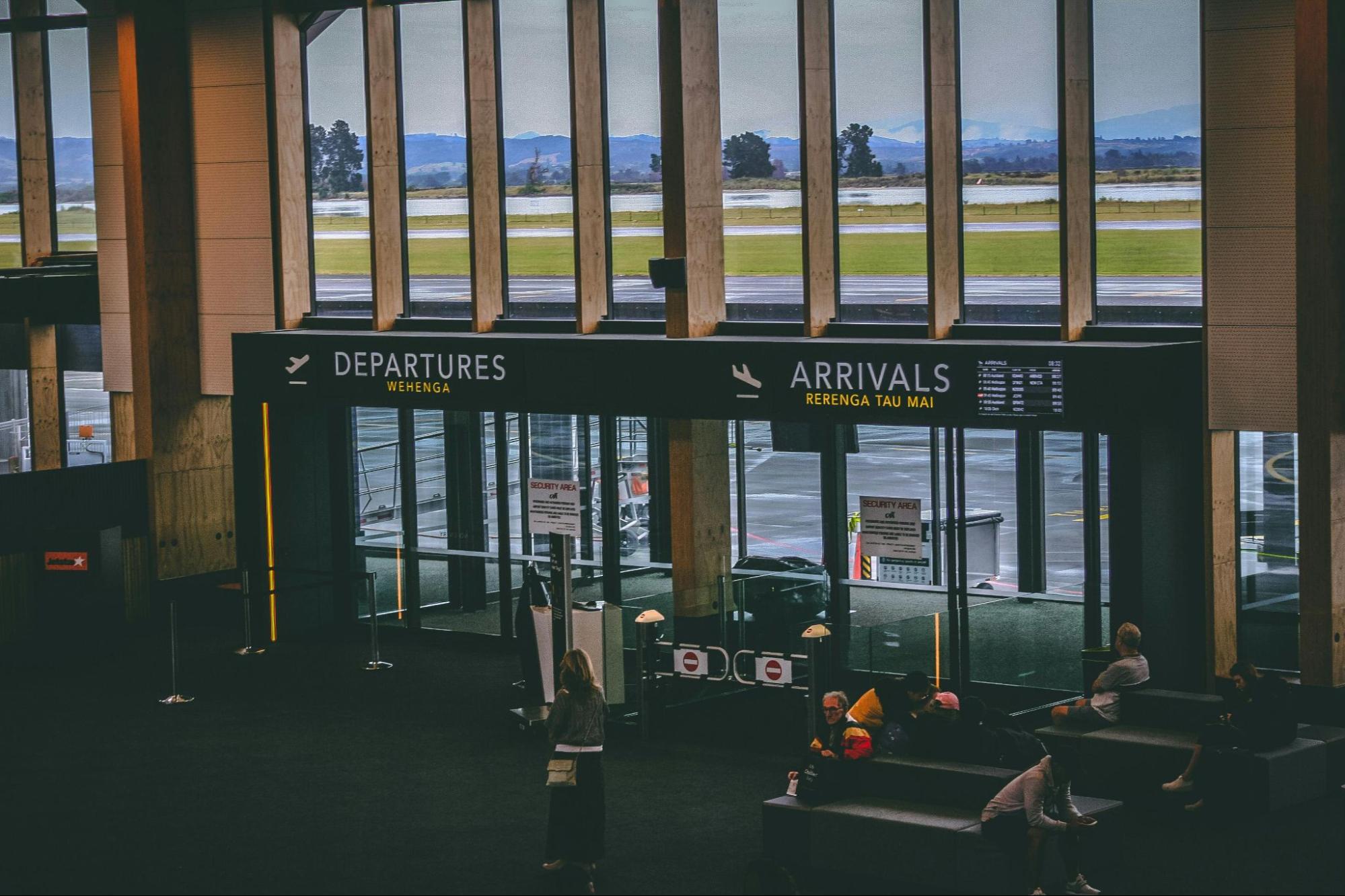 The spacious appearance of a modern airport terminal featuring clear departure and arrival signs highlights the exciting international journeys supported by the Best Immigration, Citizenship And PR Services In Singapore.